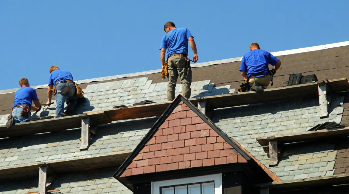 Roof replacement in progress with a team of professional contractors installing new shingles on a residential home in Milwaukee, WI